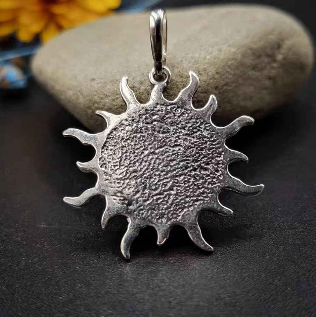 Amber Sun pendant made of blackened 925 sterling silver and red amber