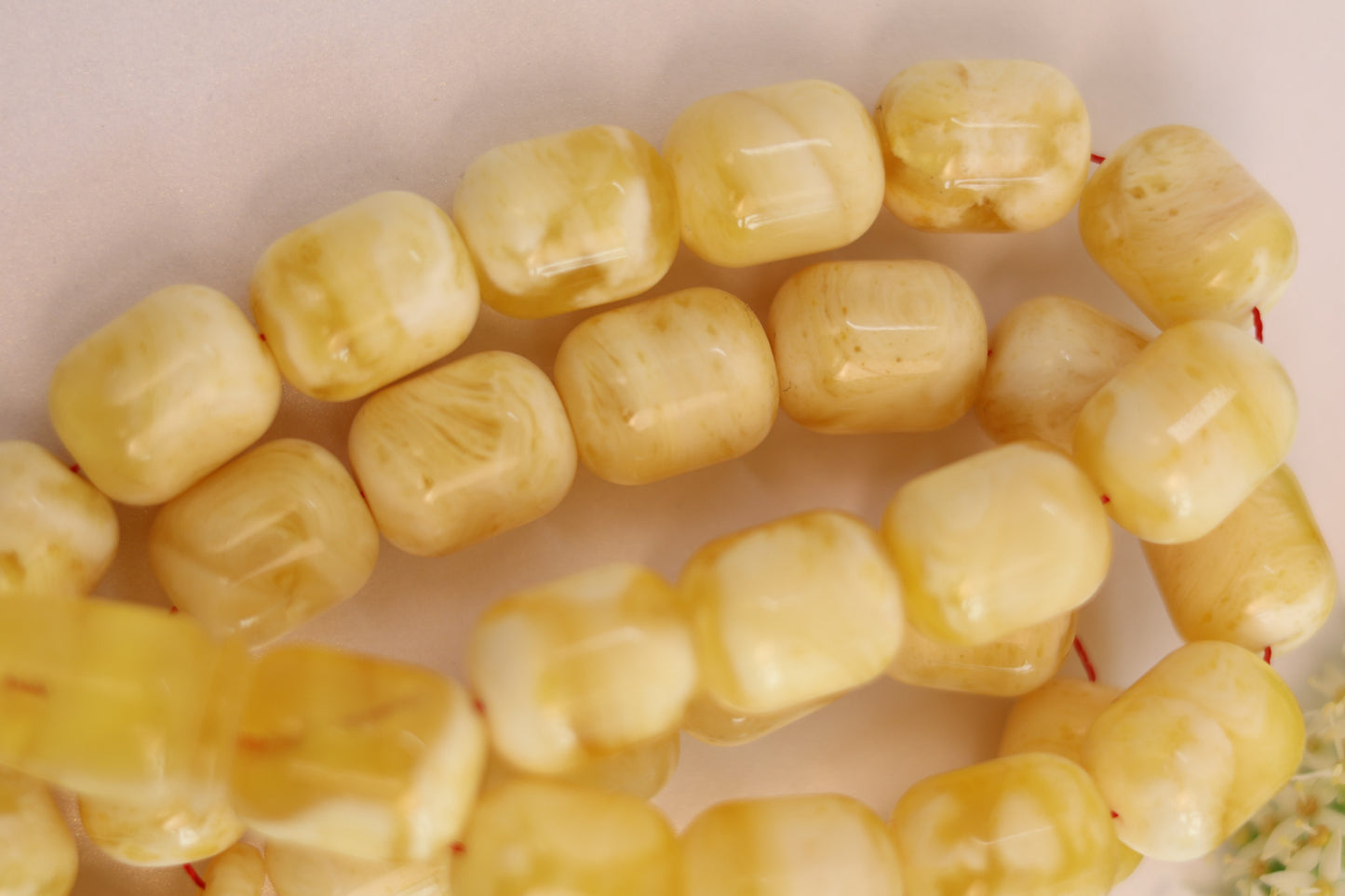 Close-up of yellow amber islamic beads on a white background