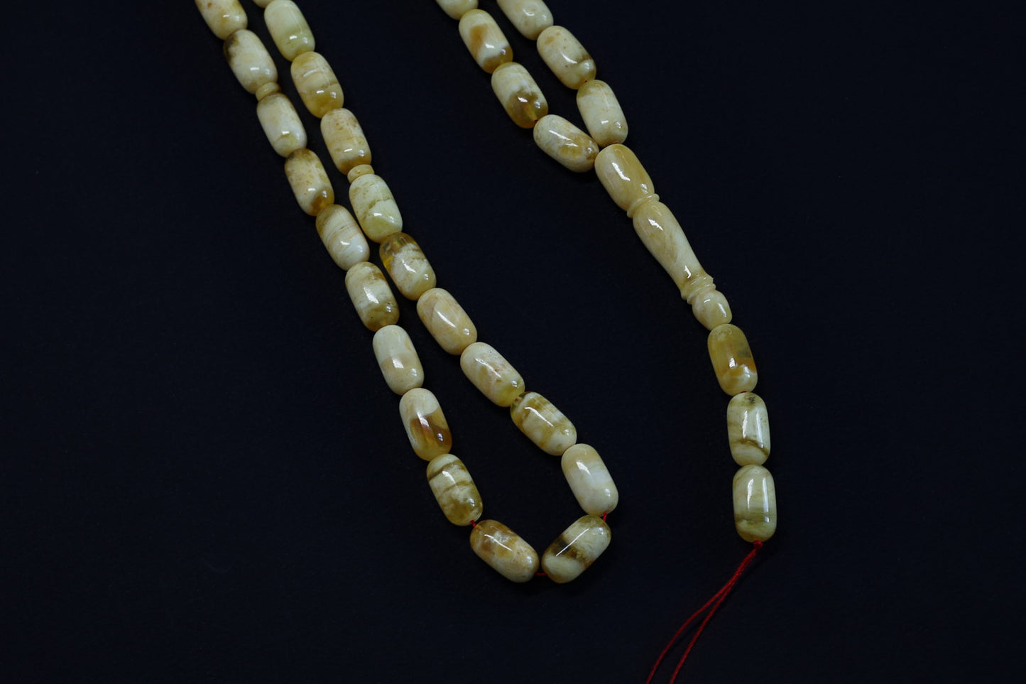 String of amber beads on a black background