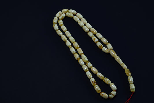 Close-up of the genuine Baltic amber Tesbih (Bernstein Gebetskette), highlighting the unique mottled yellow beads.