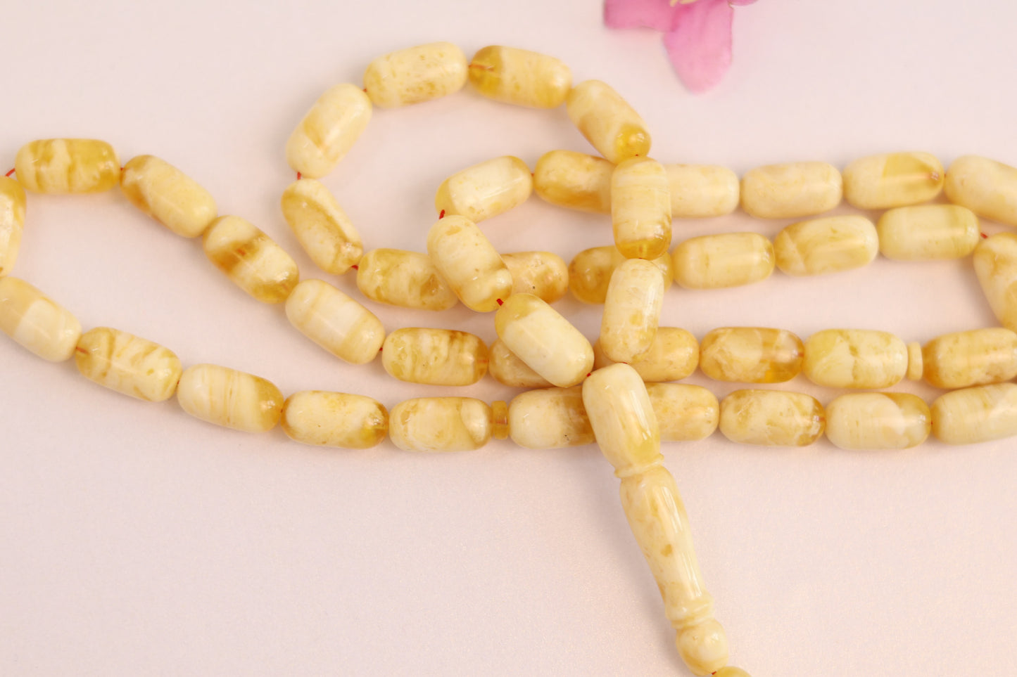 Detailed view of the كهرمان مضغوط (pressed amber) rosary, showcasing the distinctive yellow and transparent patterns.