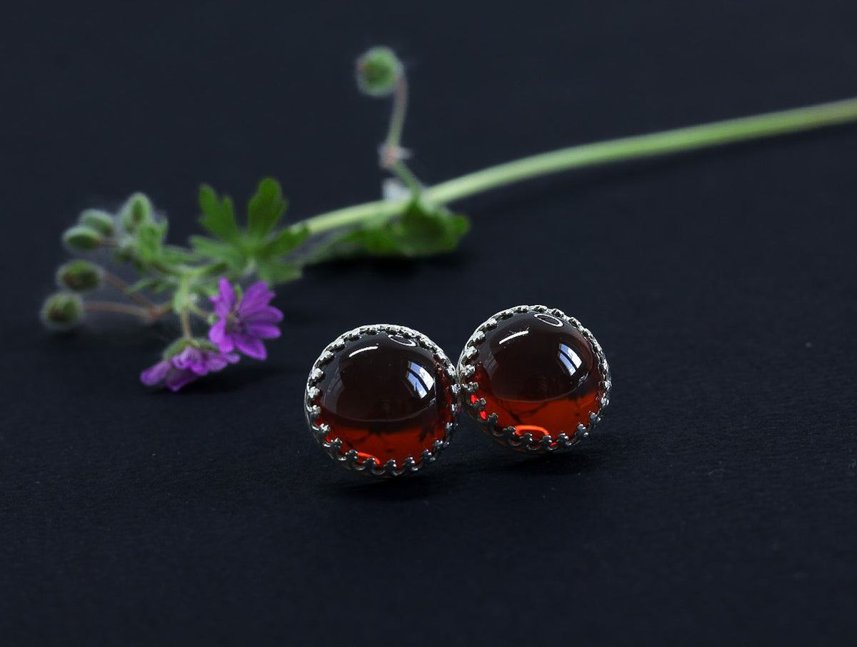 Baltische Kirschbernstein Ohrringe in eleganter Kronenfassung aus Sterling Silber. Die Abbildung zeigt die reiche, tiefe Farbe des Bernsteins.
