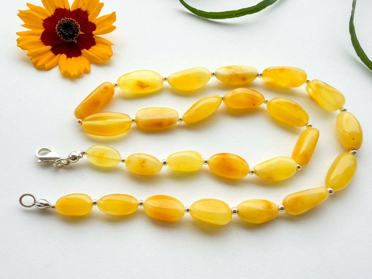 Handcrafted 50cm natural Baltic amber necklace featuring polished yellow olive beads separated by sterling silver spacer beads by Tetibel.