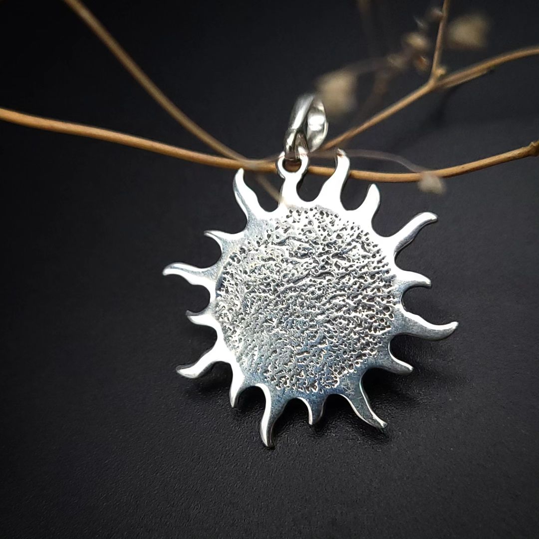 Rückseite des Sonnenanhängers aus 925er Silber mit texturierter Oberfläche.