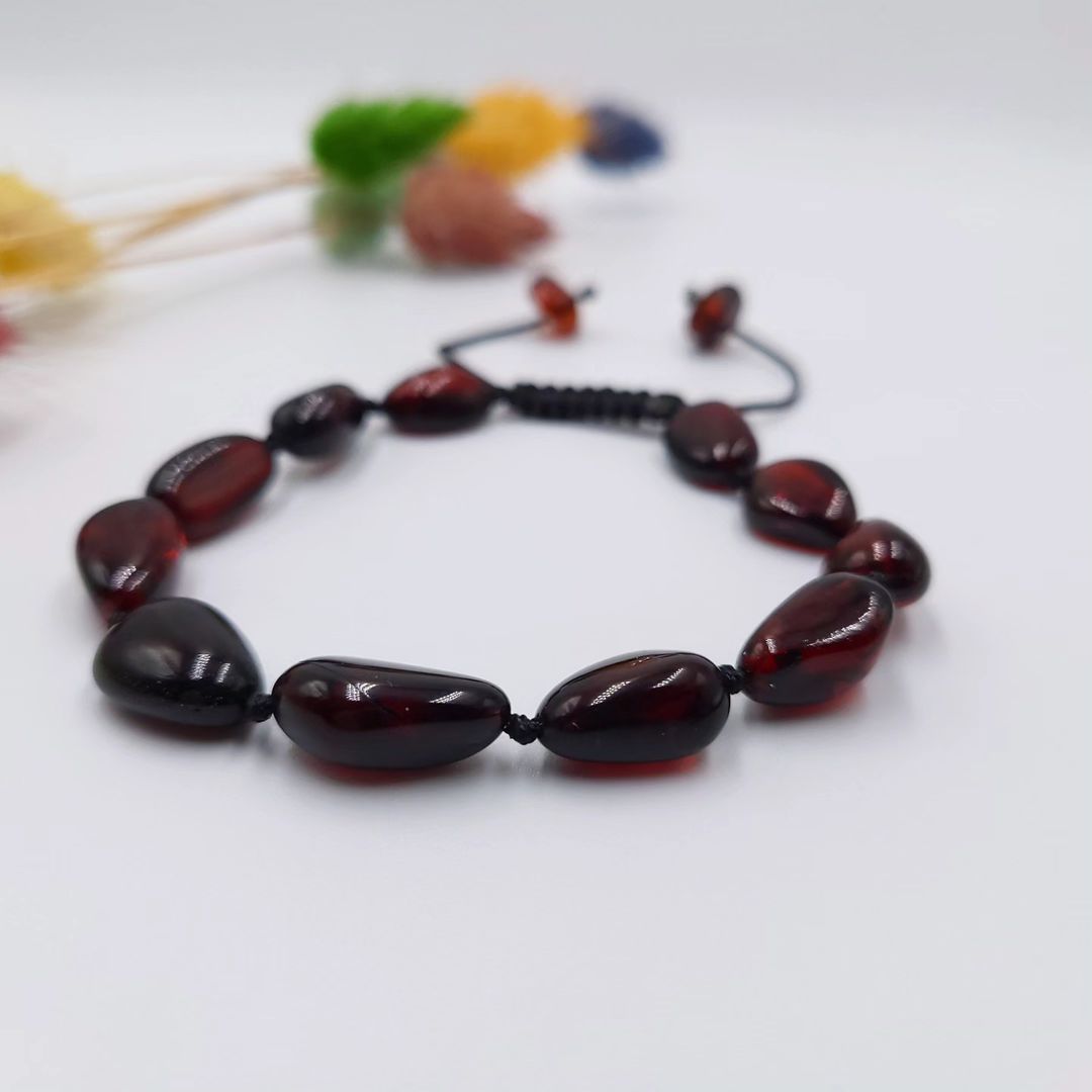 Das Tetibel Kirschbernstein Armband am Handgelenk einer Frau, demonstriert die anpassbare und elegante Passform.