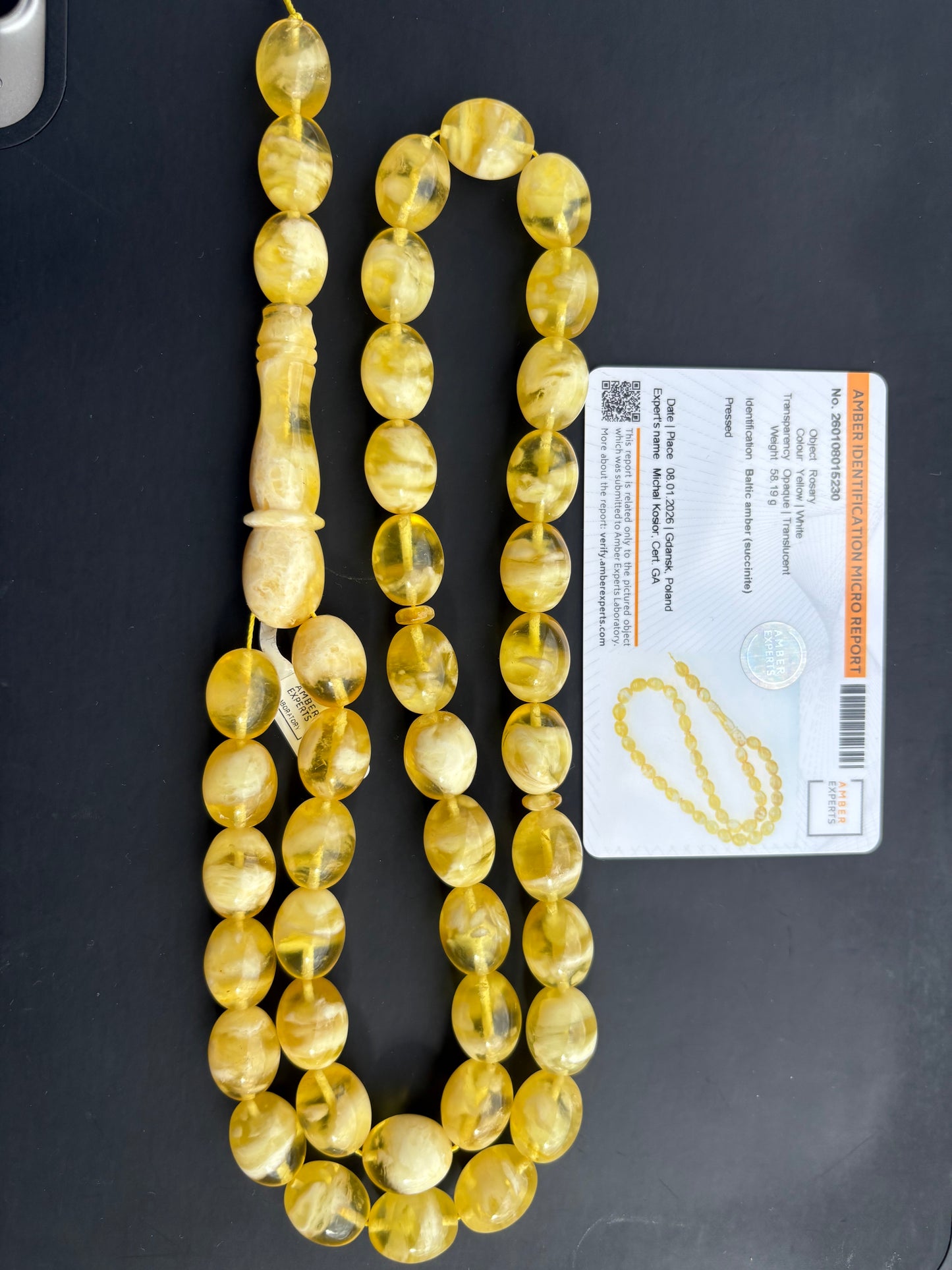 Tetibel 42-bead pressed Baltic amber rosary featuring 15x12mm translucent yellow and white oval beads paired with its authenticity micro report.