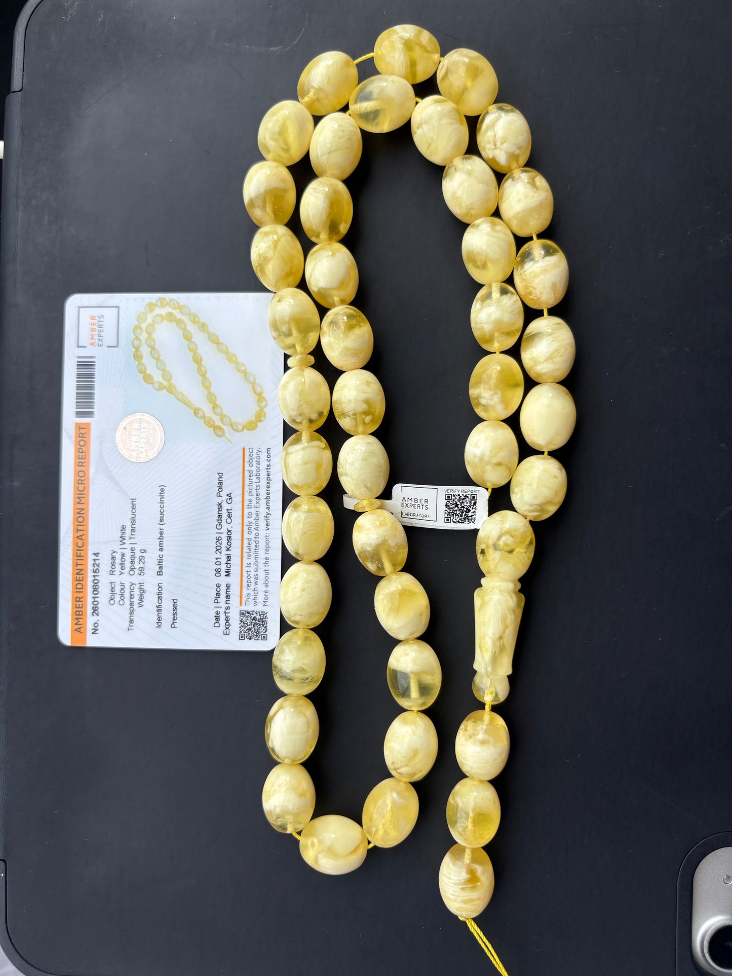 Tetibel 42-bead pressed Baltic amber rosary featuring 15x12mm yellow and white marbled oval beads shown alongside its official authenticity certificate.
