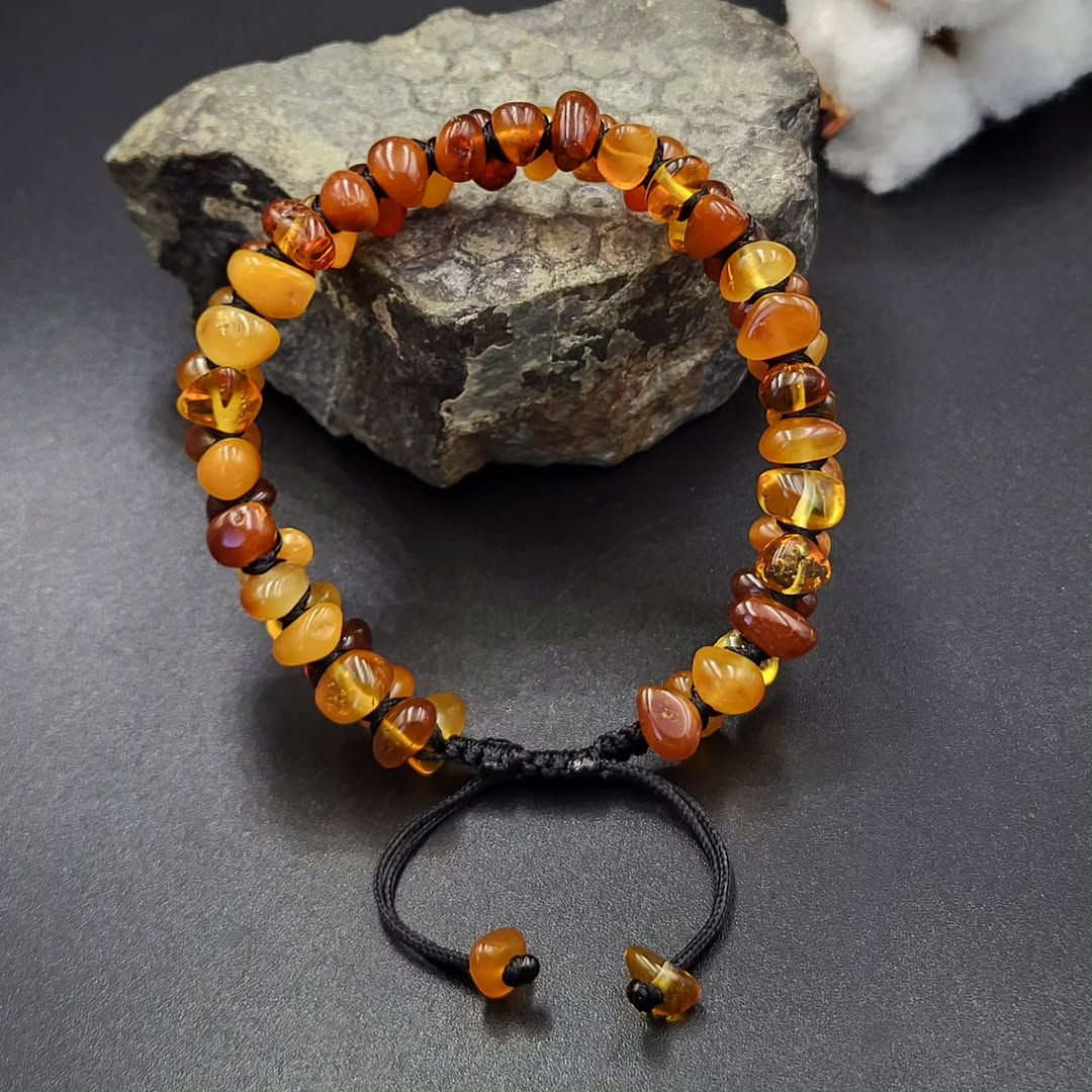 adjustable knot clasp amber bracelet on a dark surface