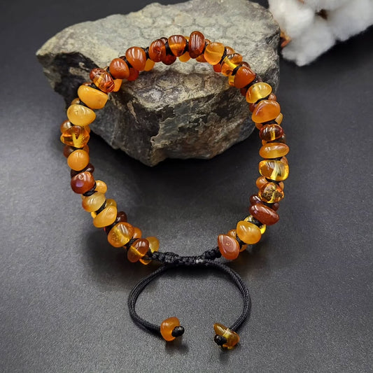 adjustable knot clasp amber bracelet on a dark surface