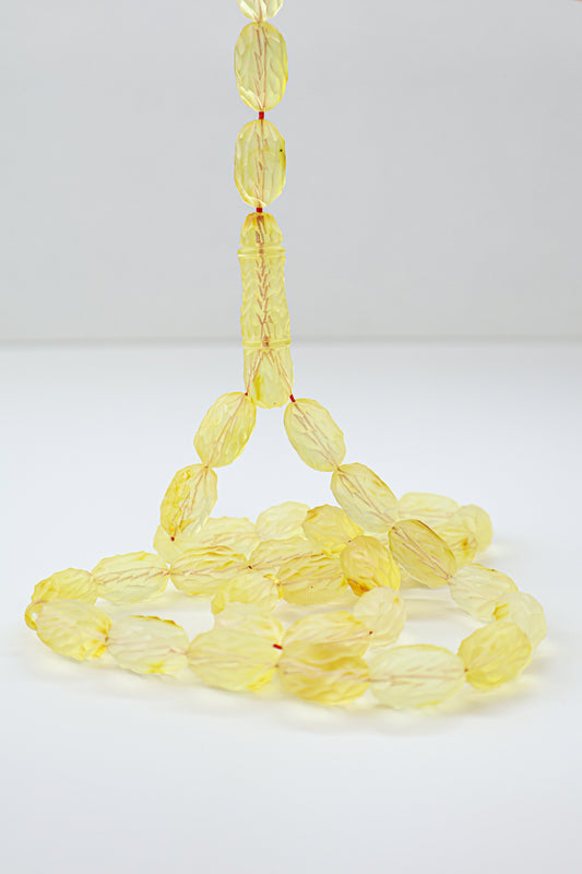 Handcrafted yellow succinite amber tasbih featuring 36 authentic 16x9.5mm handmade carved beads with natural imperfections, weight 32.60 grams.