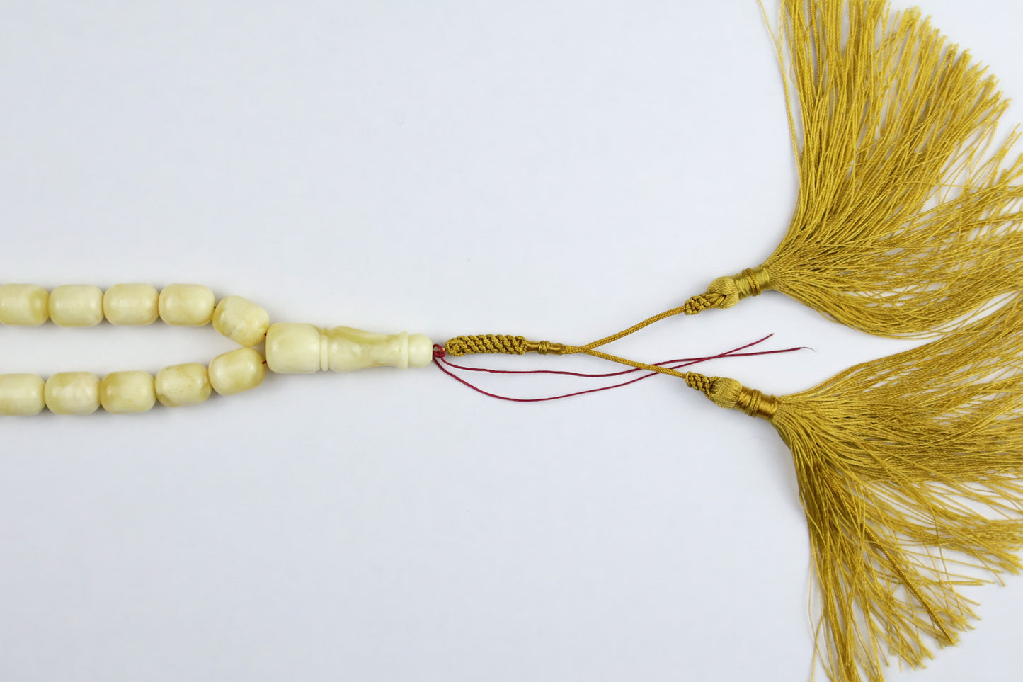 Close-up detail of golden tassel and imam bead on 57g certified Baltic amber misbaha