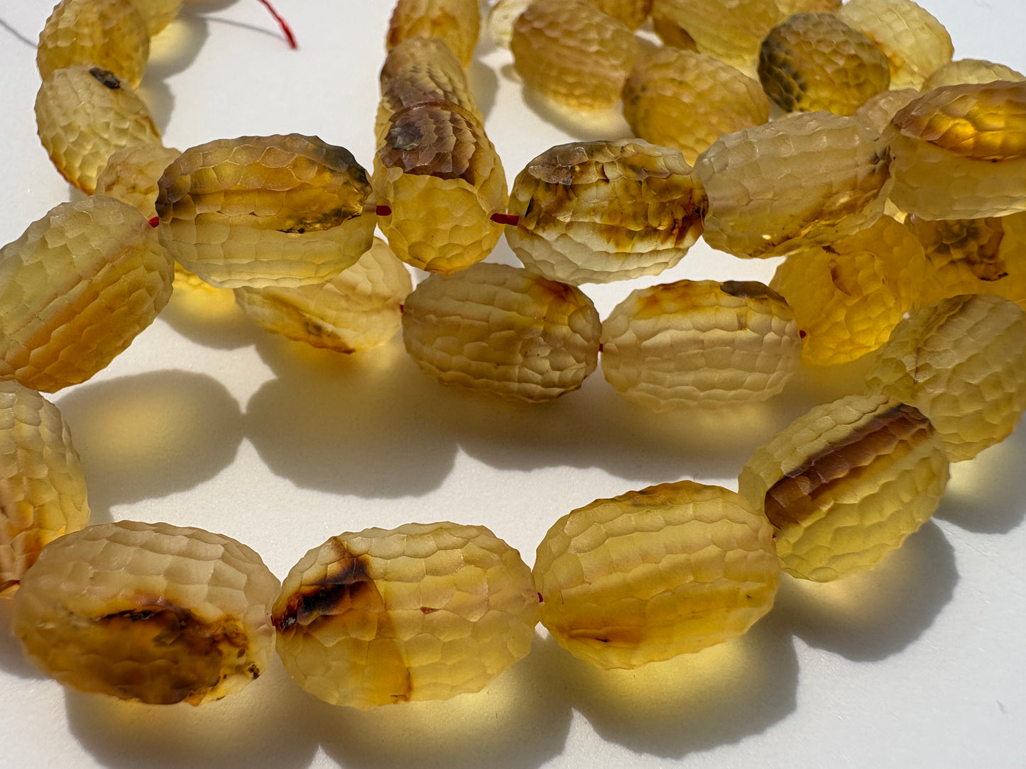 Handcrafted amber prayer beads with faceted honeycomb surface design.