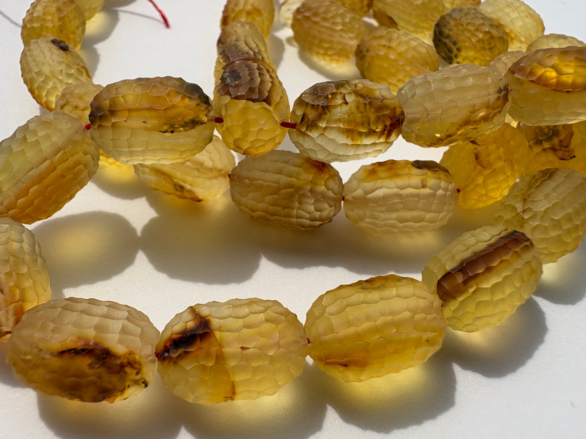 Handcrafted amber prayer beads with faceted honeycomb surface design.