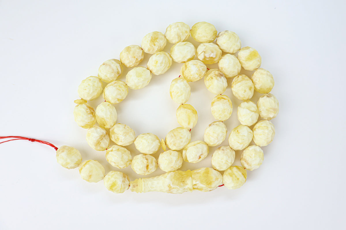 Certified hand-carved opaque yellow and white Baltic amber misbaha rosary with 42 beads measuring 15x11.5 mm by Tetibel.