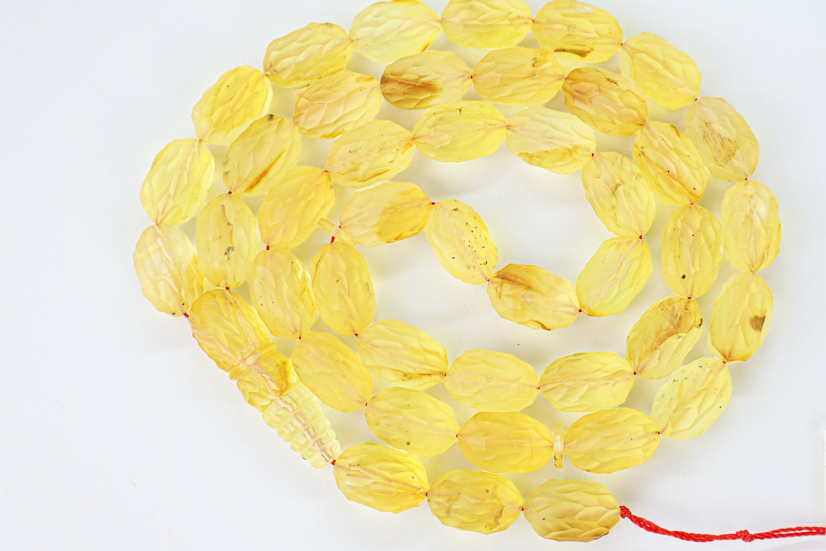 Handcrafted yellow and brown succinite amber tasbih featuring 42 authentic 16.5x10.5mm faceted beads with minor natural imperfections, weight 44.66 grams.