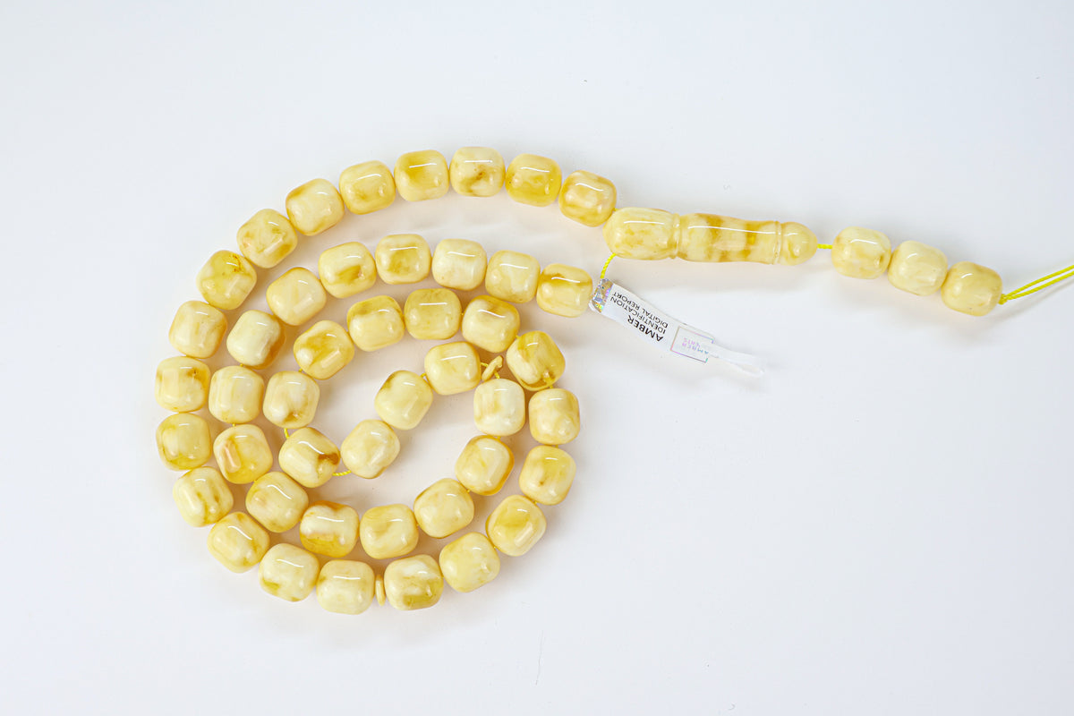 Authentic white-yellow Baltic amber misbaha strand displaying creamy white and yellow resin patterns.
