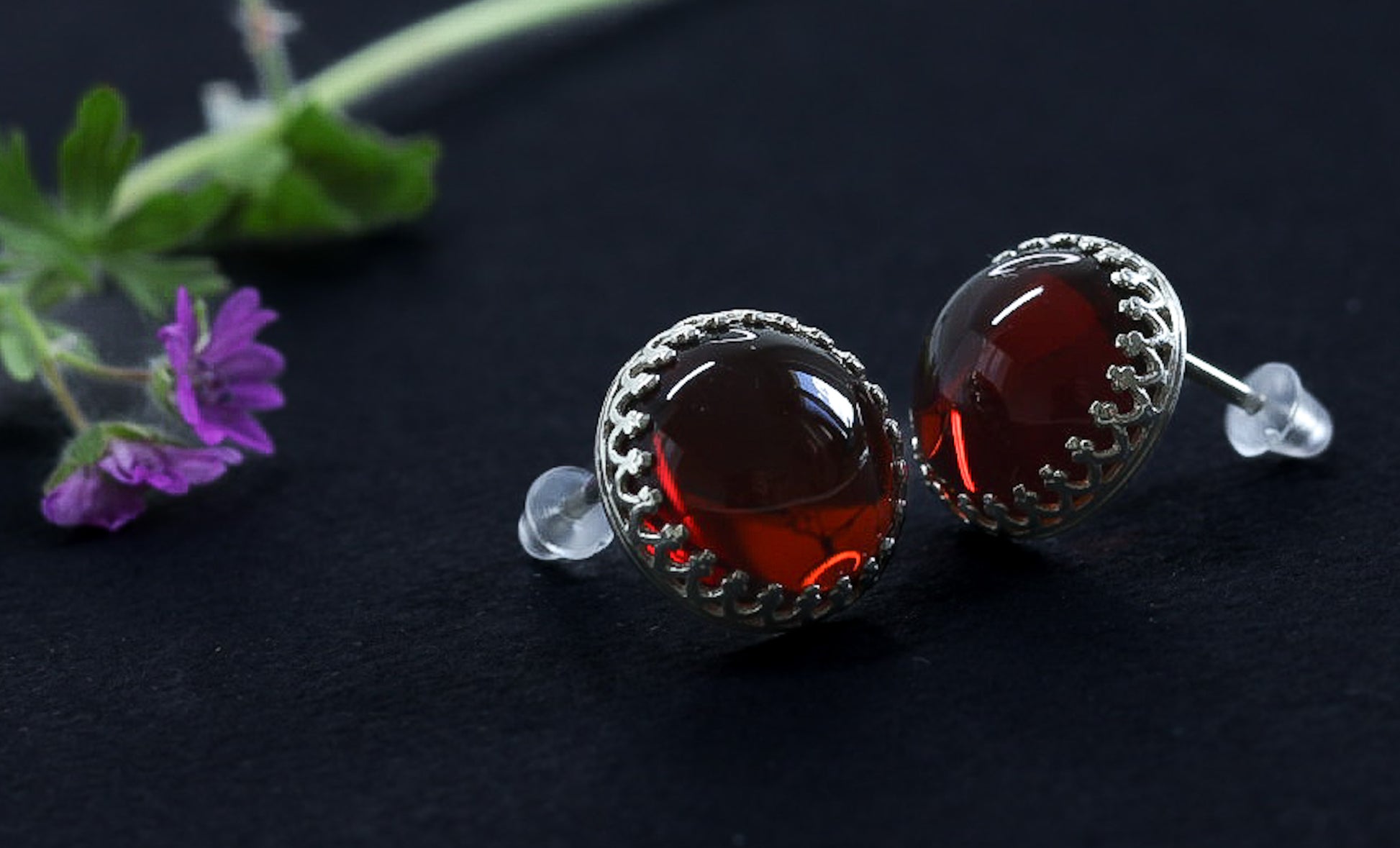 Nahaufnahme der Cognac Bernstein Ohrstecker von Tetibel Jewels in 925 Sterling Silber. Die beiden Ohrstecker (⌀12mm) liegen nebeneinander.