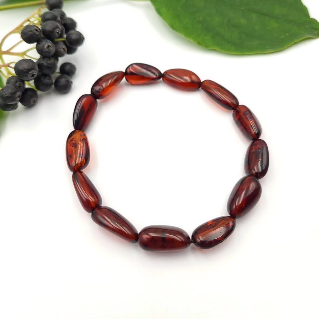 Polierte Olivenperlen in tiefem Kirschbernstein und Cognac Tönen.