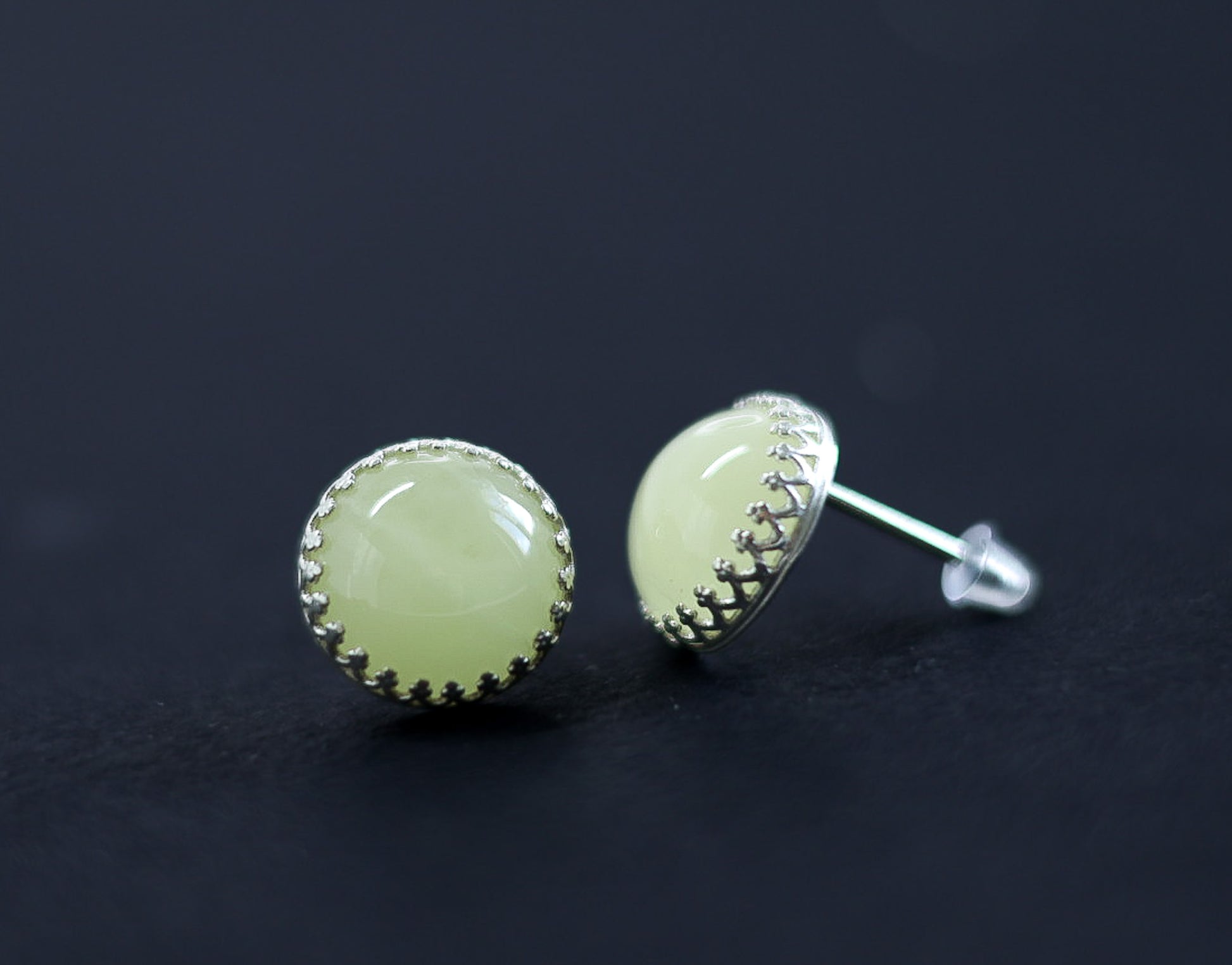 Baltic amber stud earrings from Tetibel Jewels, showing the lemon milky amber securely placed in a decorative sterling silver crown setting