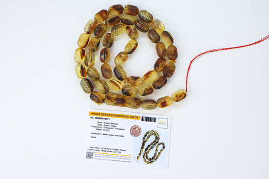 Authentic grooved hand-carved Baltic amber misbaha strand with plant leftovers and custom Doha blue and white tassel.