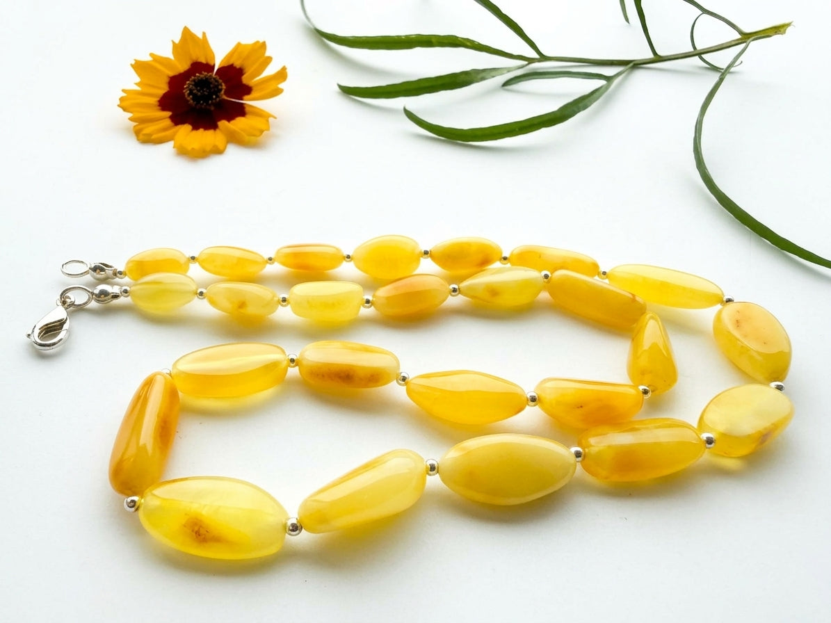 Natural yellow Baltic amber necklace display showing smooth freeform beads and silver findings by Tetibel Amber Jewels.