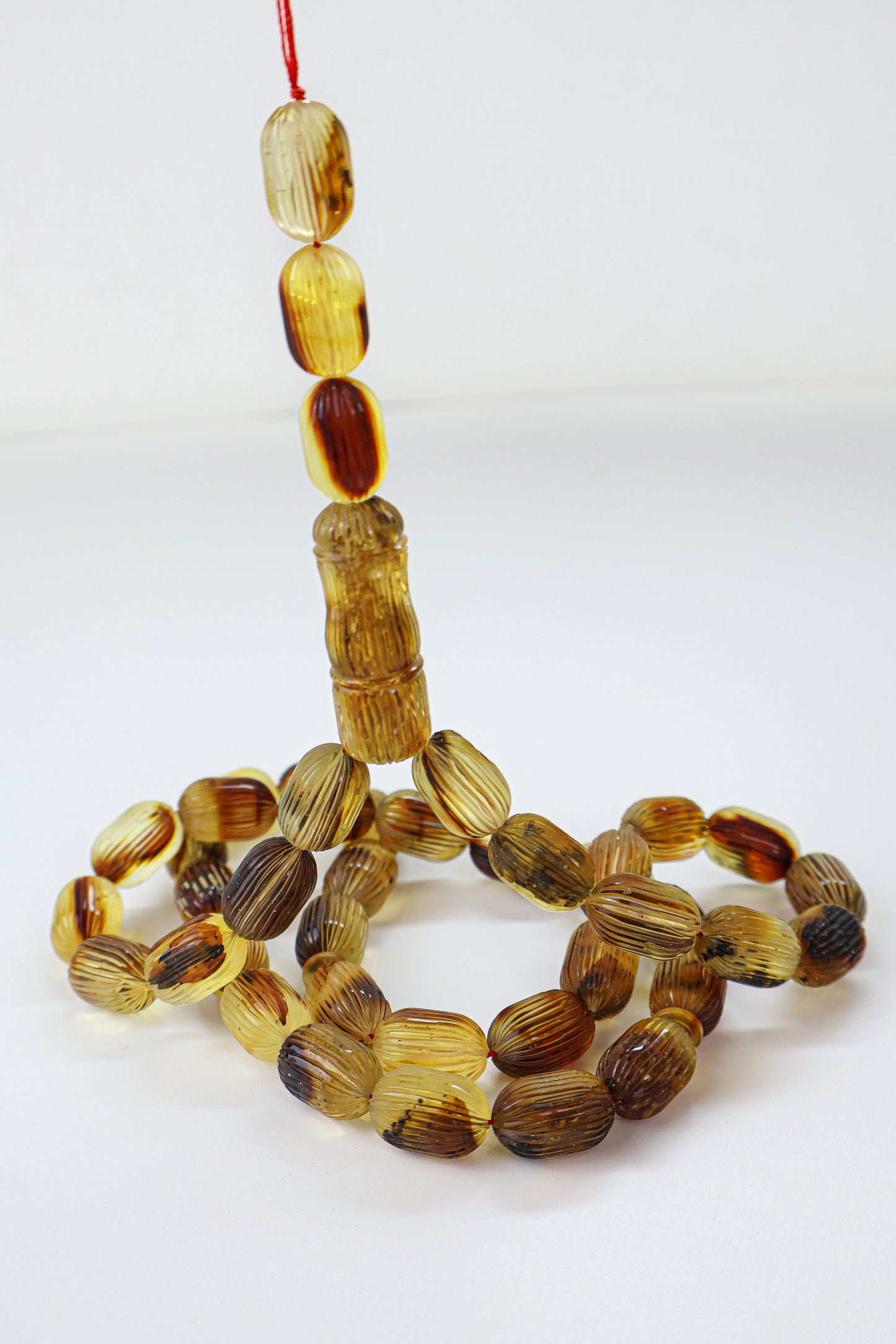 Certified natural hand-carved brown Baltic amber misbaha rosary with plant inclusions and 42 beads measuring 16.5x10.5 mm by Tetibel.
