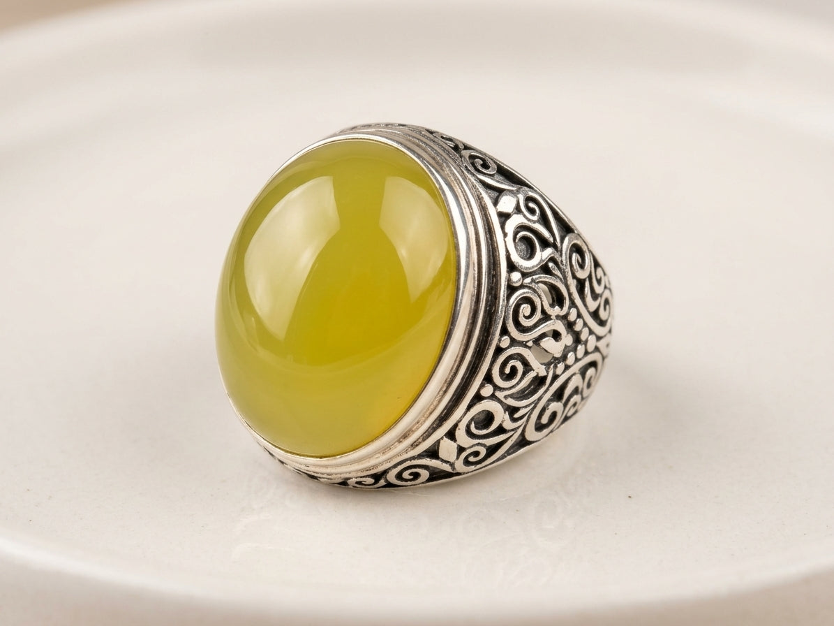 Handcrafted sterling silver filigree ring featuring a polished high-dome translucent yellow natural Baltic amber cabochon by Tetibel.