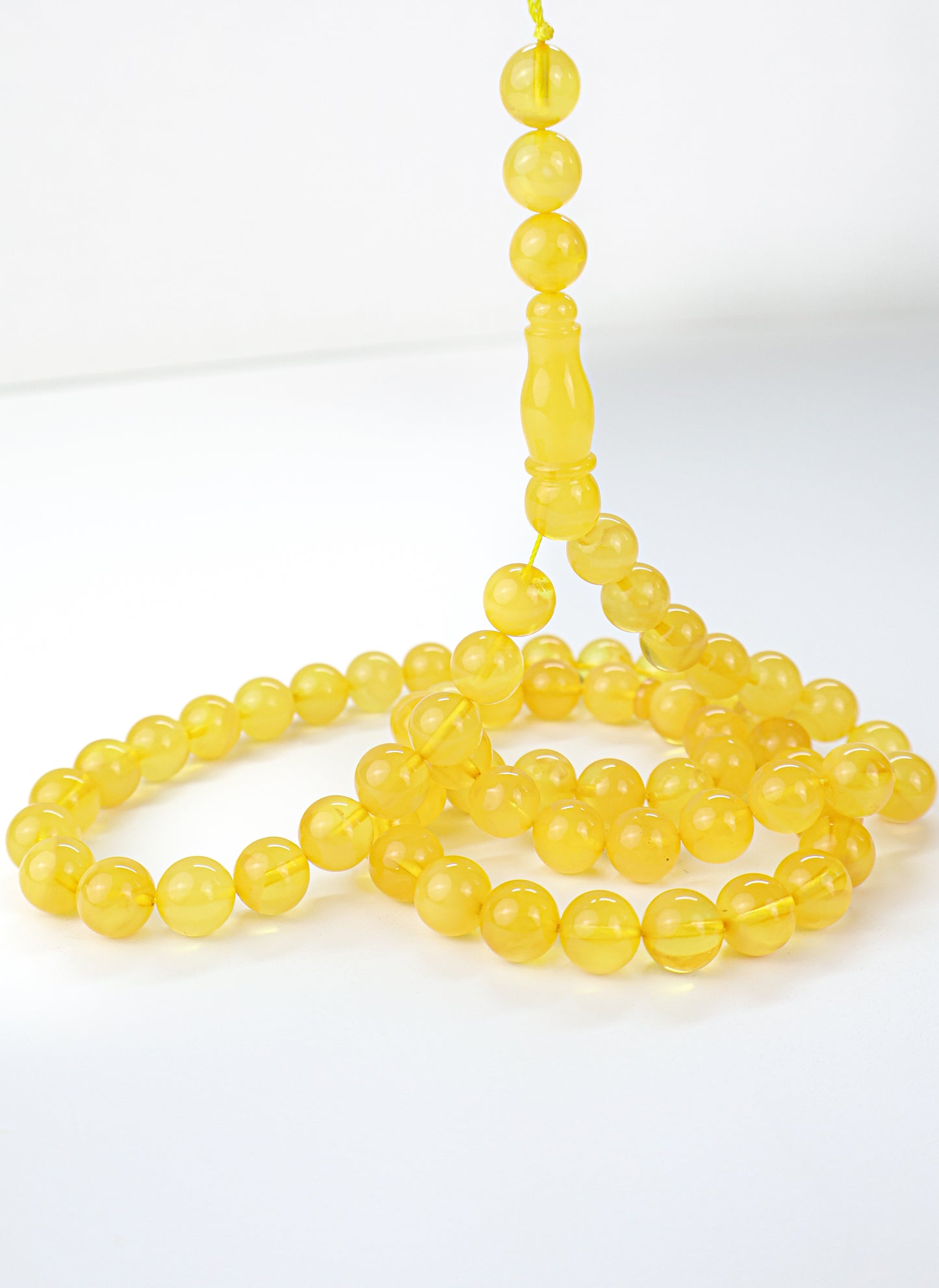Handcrafted dark yellow succinite amber tasbih featuring 69 authentic 10mm round beads, weight 42.67 grams.