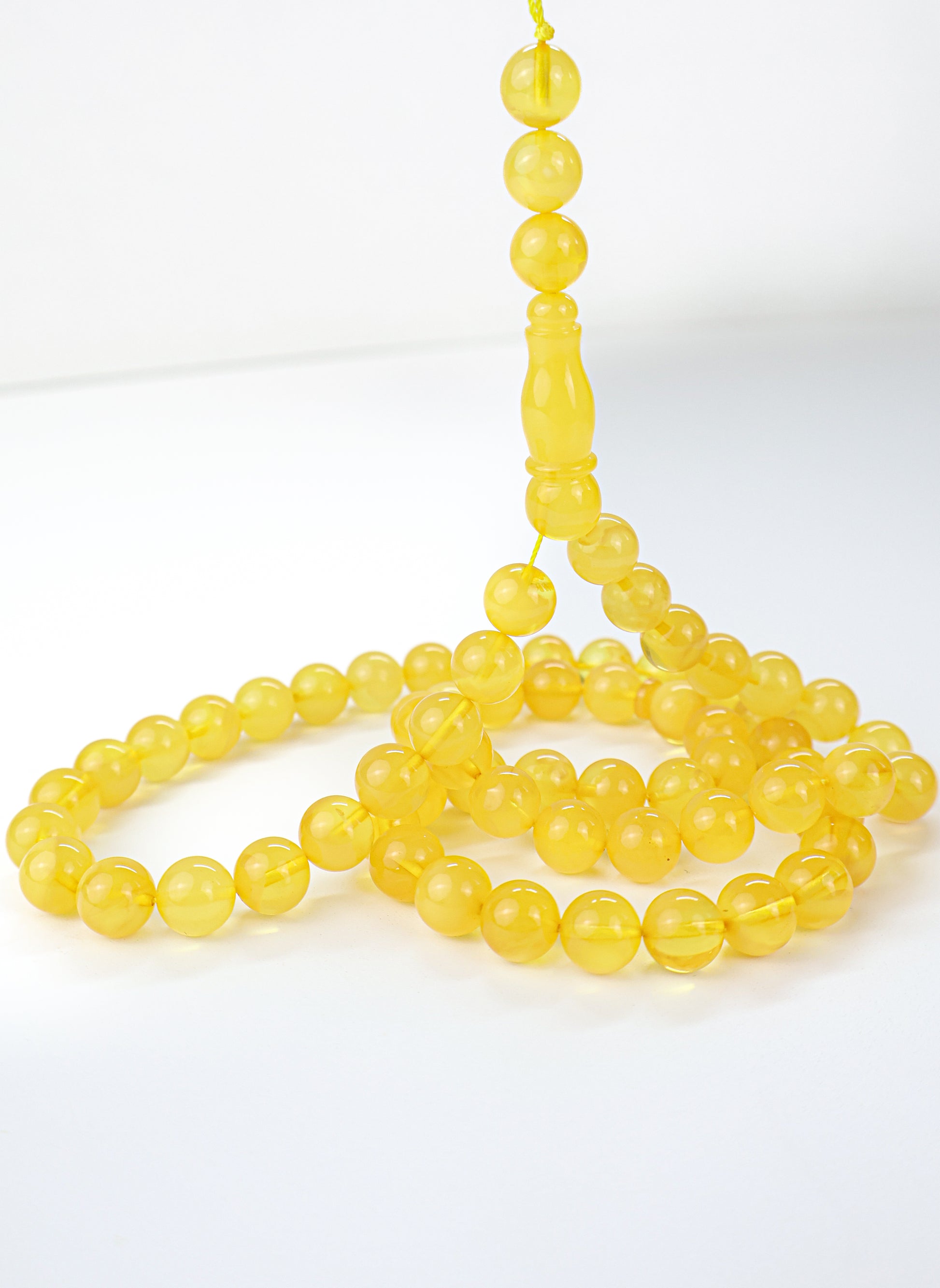 Handcrafted dark yellow succinite amber tasbih featuring 69 authentic 10mm round beads, weight 42.67 grams.