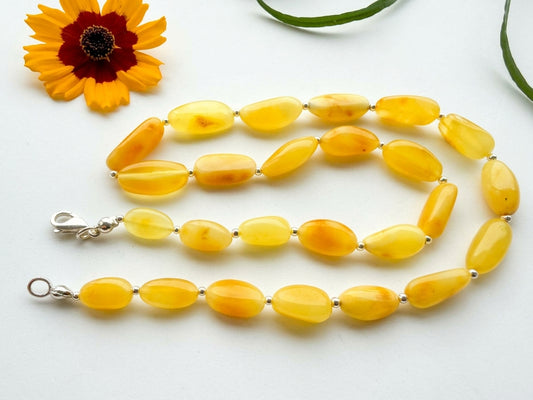 Handcrafted 50cm natural Baltic amber necklace featuring polished yellow olive beads separated by sterling silver spacer beads by Tetibel.
