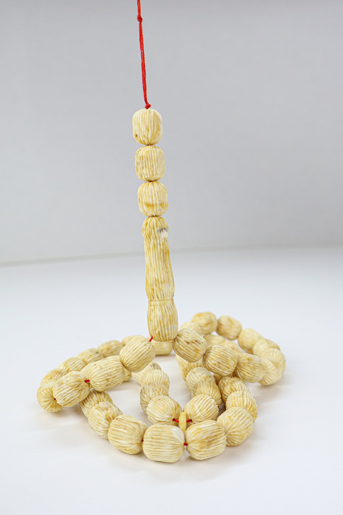 Handcrafted beige and brown succinite amber tasbih featuring 48 authentic 12x10mm handmade carved beads with natural character marks, weight 42.63 grams.