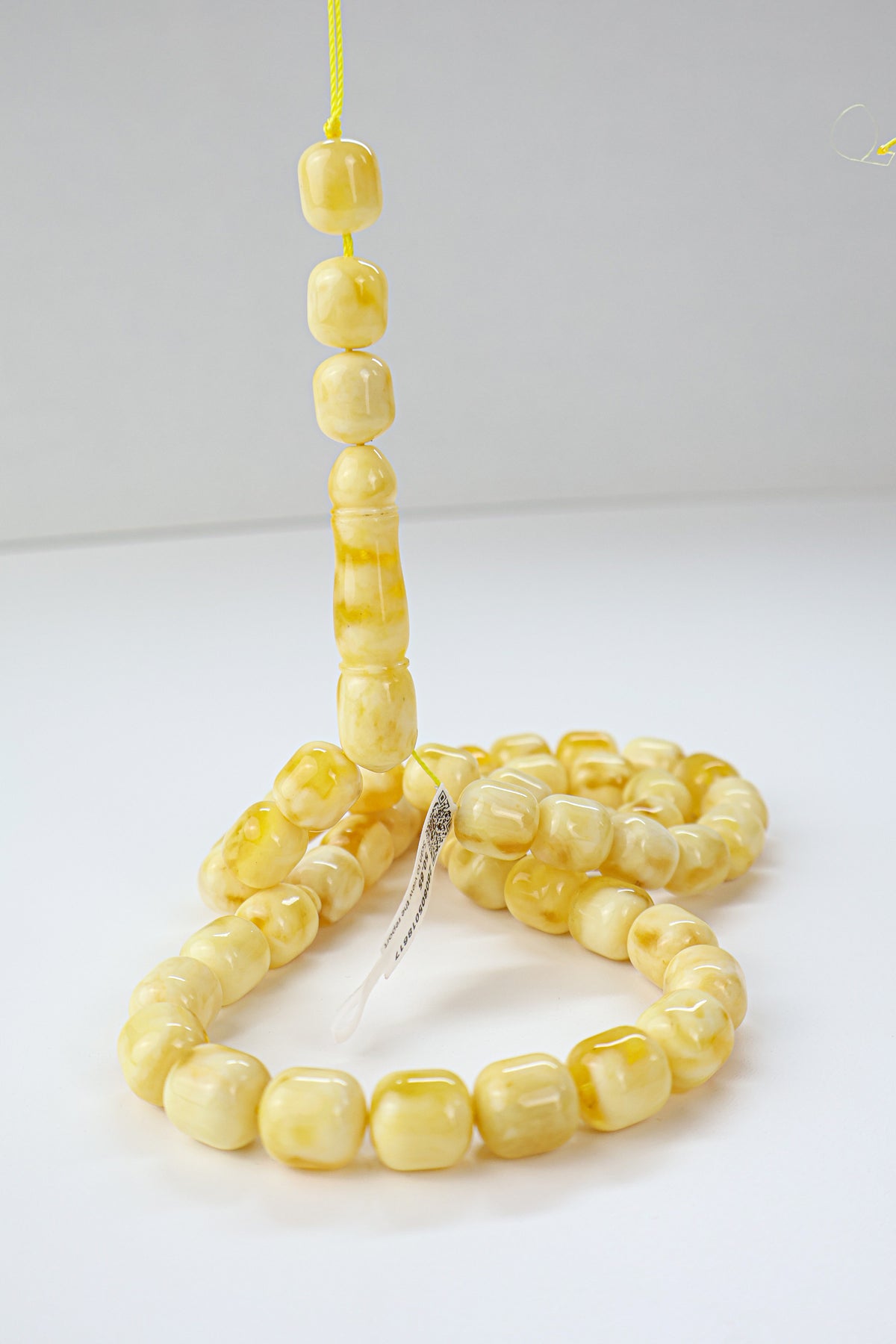 White and yellow succinite amber tasbih featuring opaque to translucent swirled beads, weight 50.65 grams.
