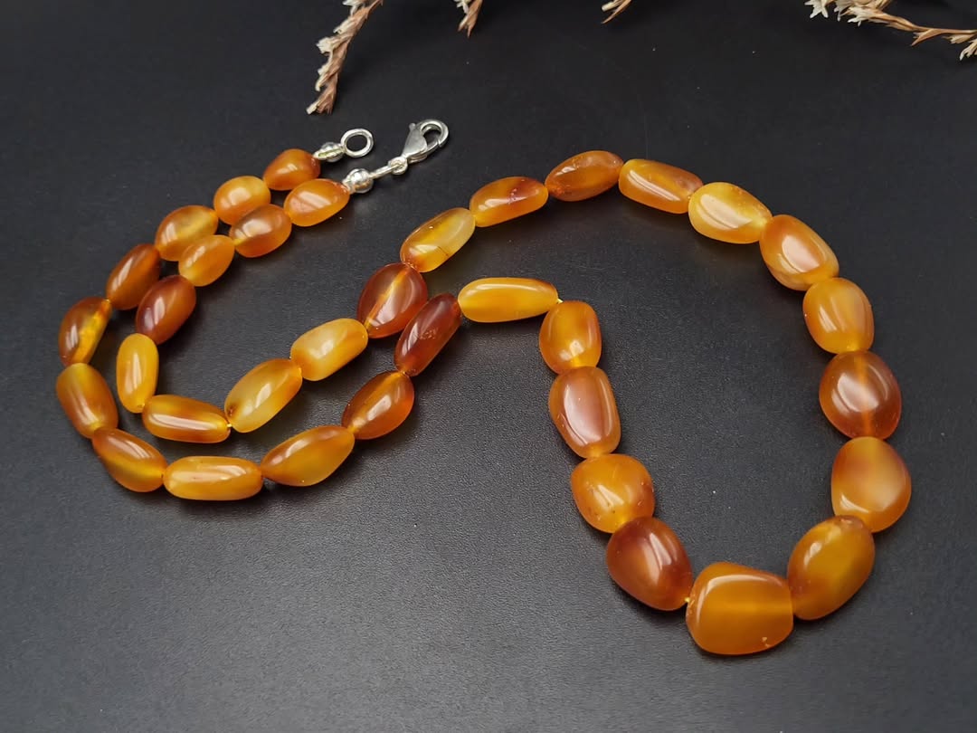 Necklace with amber-colored beads on a dark surface