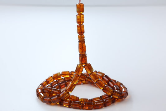 Cognac pressed Baltic amber rosary with detailed imam piece and polished barrel beads