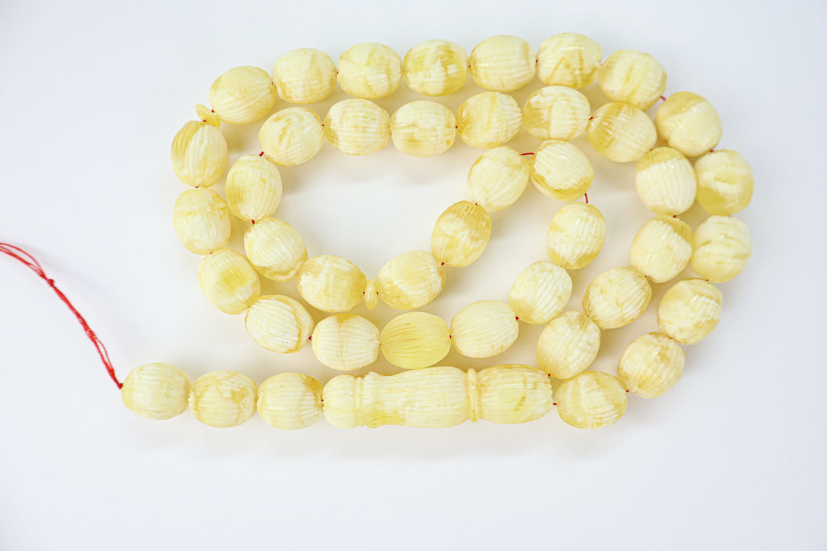 Handcrafted yellow and white succinite amber tasbih featuring 42 authentic 14.5x12mm handmade carved beads, weight 56.48 grams.
