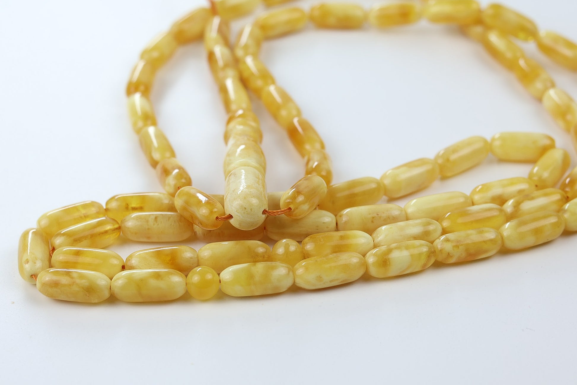 Detailed view of yellow pressed amber prayer beads with oval barrel beads and polished imam, Tetibel handmade tasbih for German buyers.