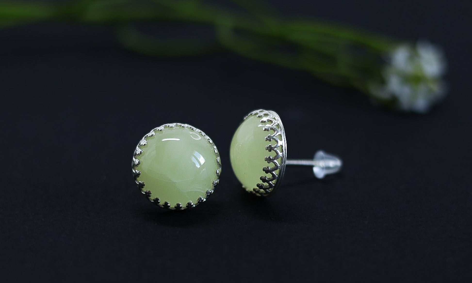 Tetibel's handcrafted Baltic amber and silver stud earrings, emphasizing the unique texture of the silver bezel and the lightness of the 2.3g design