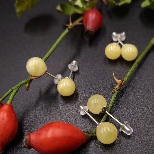 Drei Paare Lemon Baltischer Bernstein Kugel-Ohrstecker (⌀7mm, ⌀8mm, ⌀9mm) mit Silberstiften auf schwarzem Hintergrund.