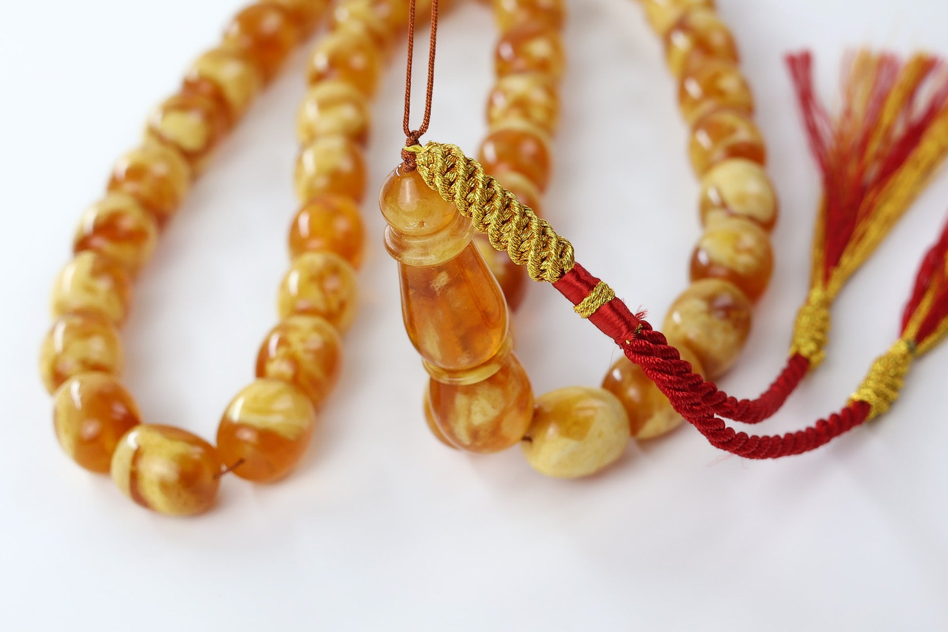 Macro close up of pressed Baltic amber imam bead, glossy honey succinite rosary by Tetibel